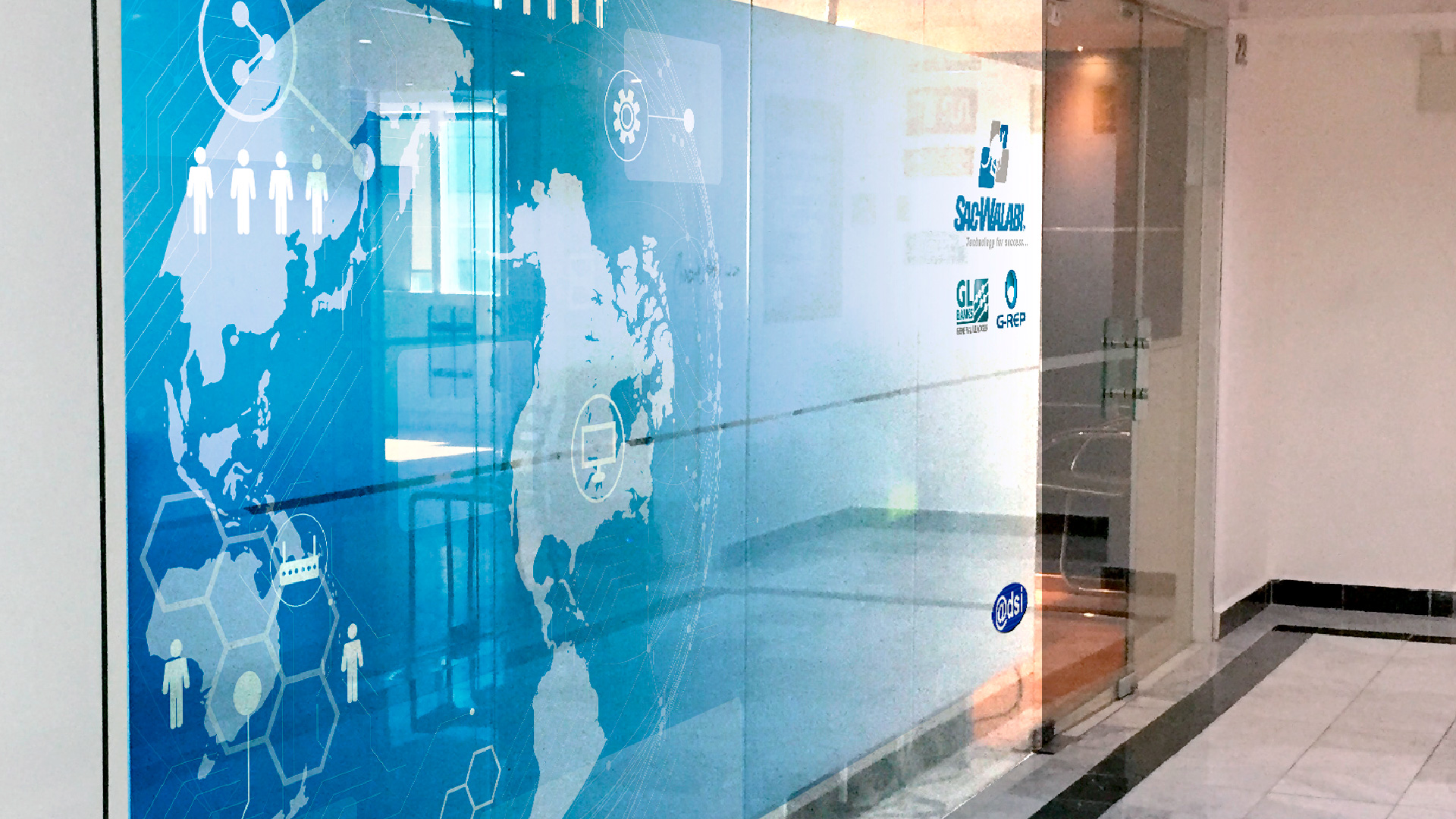 Mapa decorativo en vinil en la entrada de las oficinas de SAC-WALABI, reflejando su enfoque global en soluciones tecnológicas.